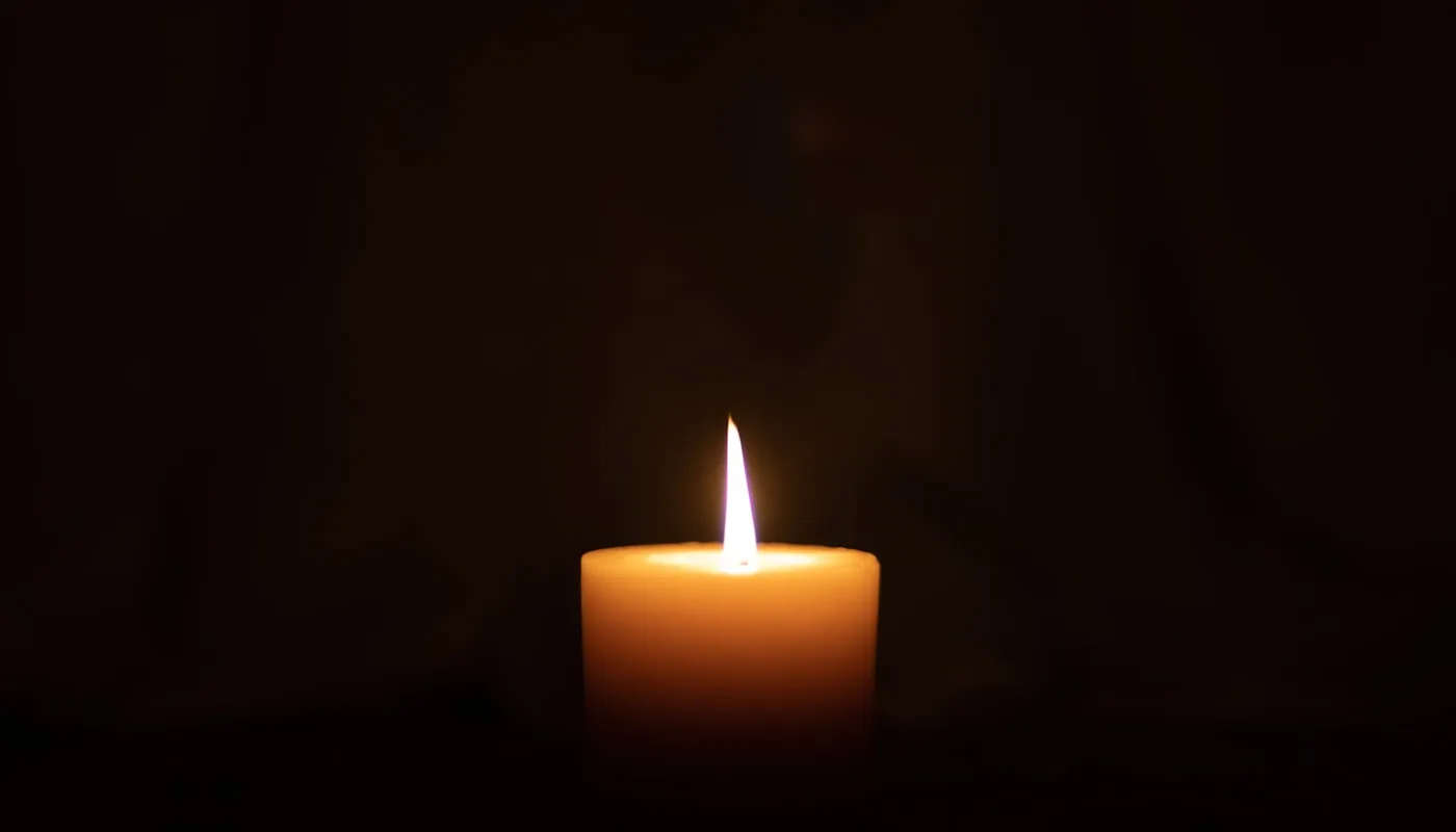 Una vela encendida en una habitación en penumbra