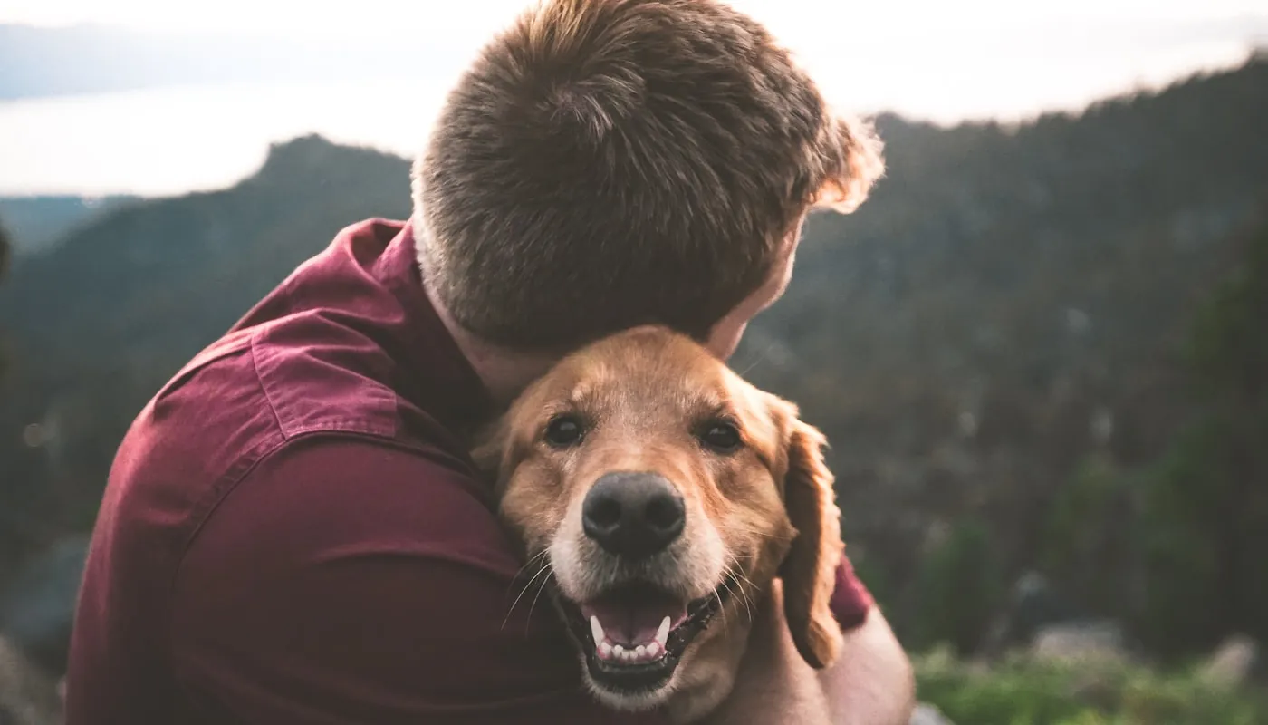 Un hombre abrazando a su perro