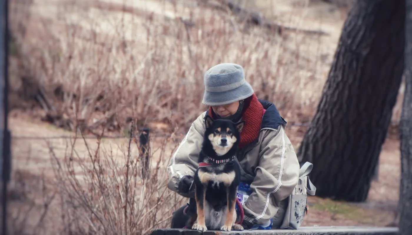 Una persona y su perro sentados juntos en un banco